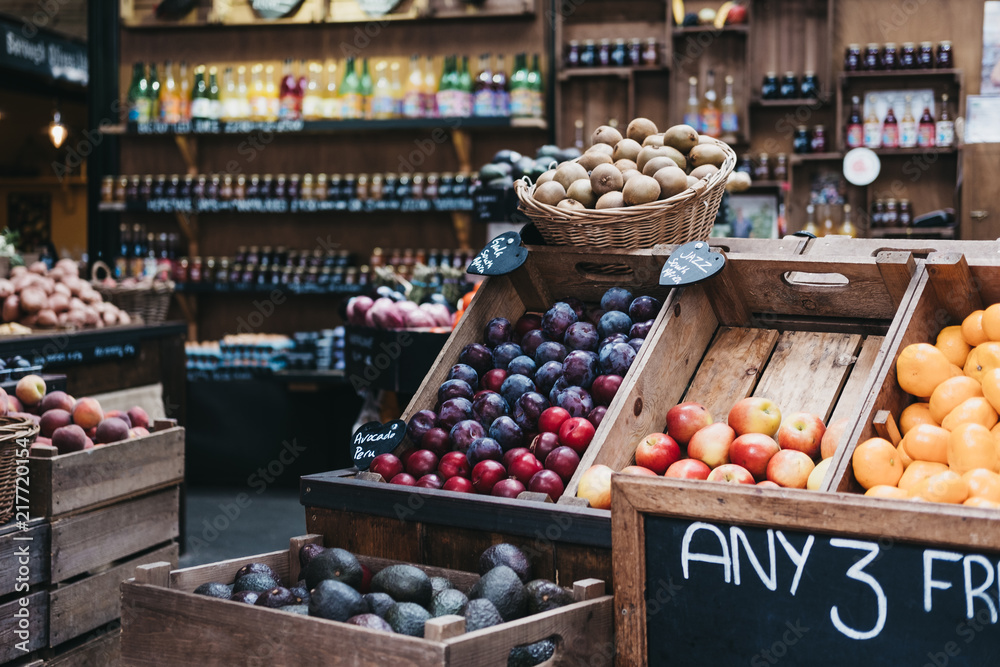各种新鲜水果和蔬菜装在木箱里，在市场摊位上出售。