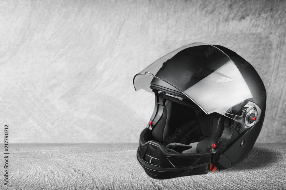 Black biker helmet on gray background