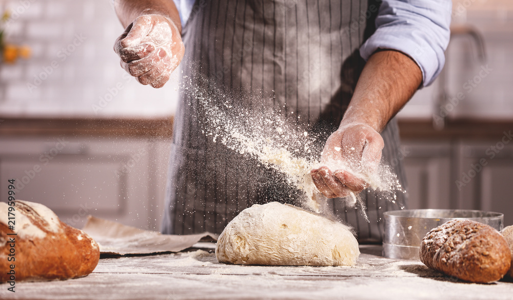 hands of bakers male knead dough