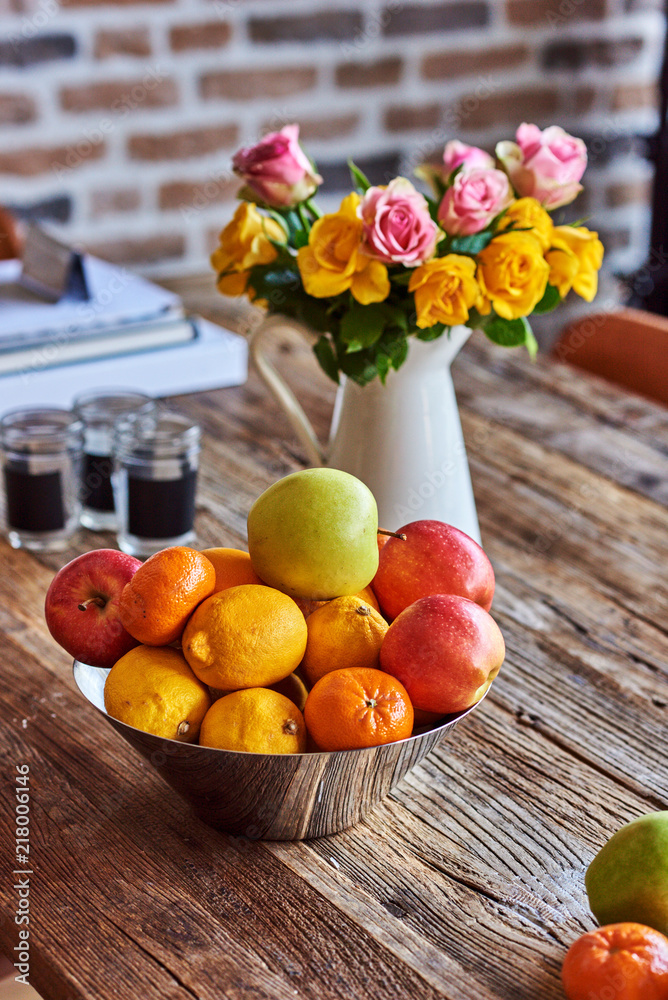 木质复古餐桌上的夏日花朵和水果的香气。怀旧的复古夏日背景。