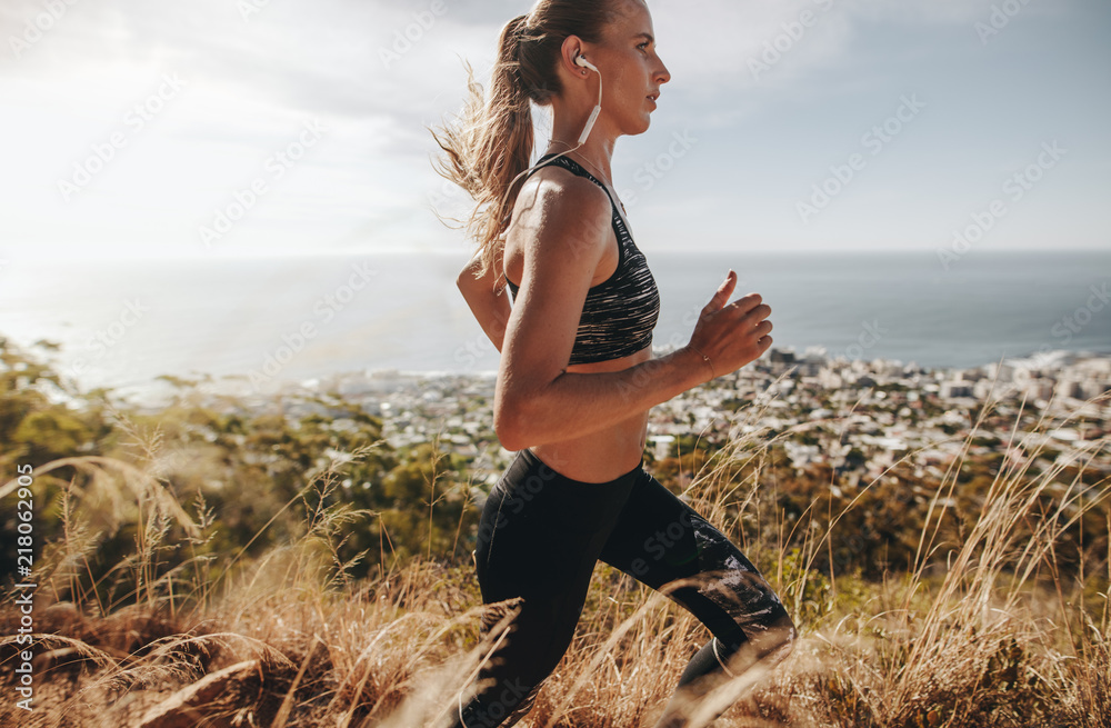 健康的女人在山间小道上奔跑