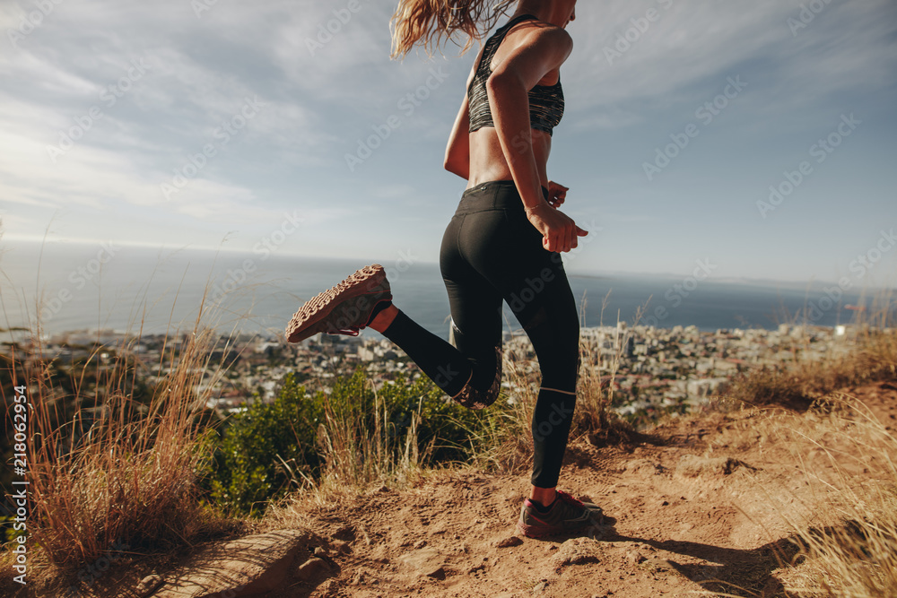 年轻女子在岩石小路上慢跑