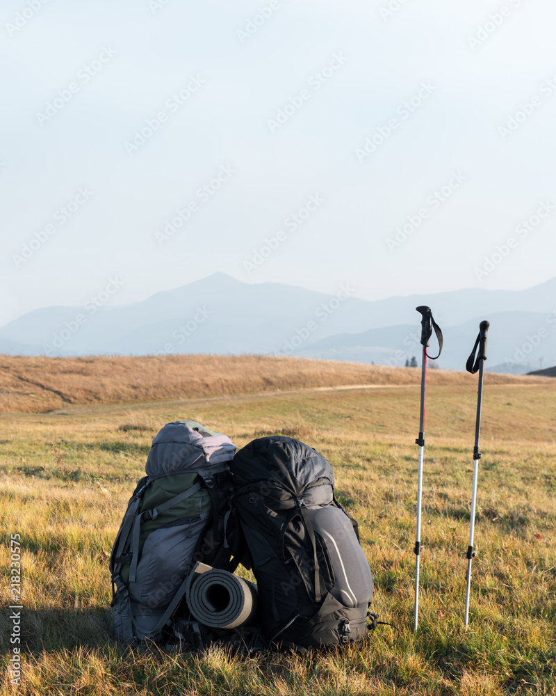 两个背包，背景是令人难以置信的山脉景观。高地阳光明媚。Touri