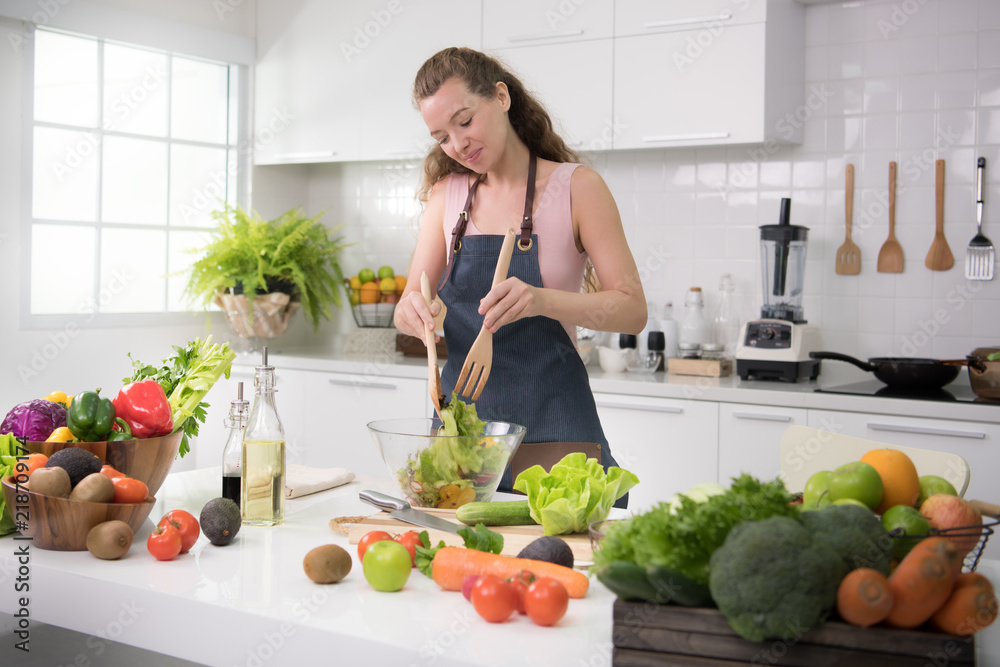 健康的年轻女性在厨房里为健康的膳食和沙拉准备蔬菜