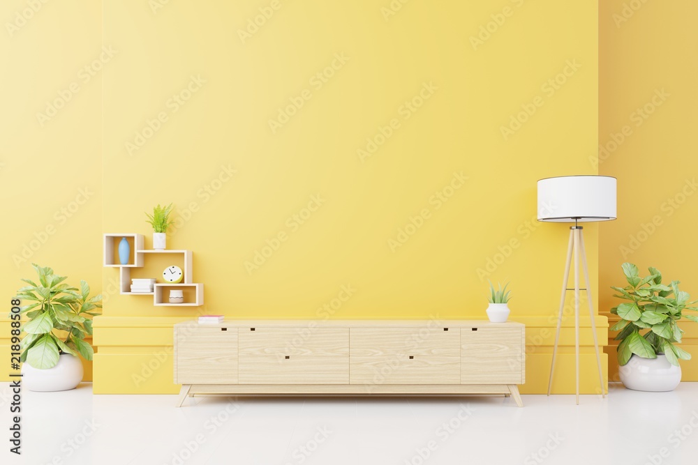 现代客厅的电视柜或放置物品的柜子，黄色墙上有灯、桌子、花草