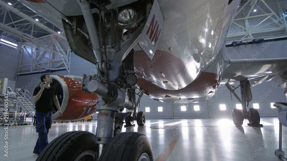 在机库里，飞机维修工程师/技术员/机械师目视检查飞机底盘