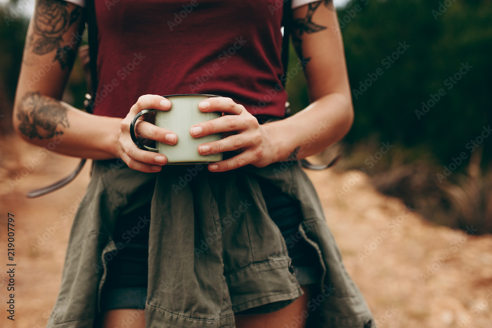 女人在森林里徒步旅行时拿着咖啡杯