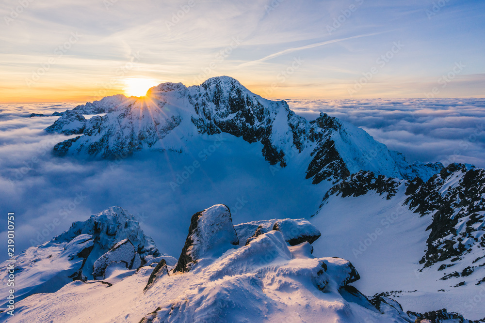 在冬季高山般的雪景中，令人惊叹的日落或日出。反转，太阳星在后面达到顶峰