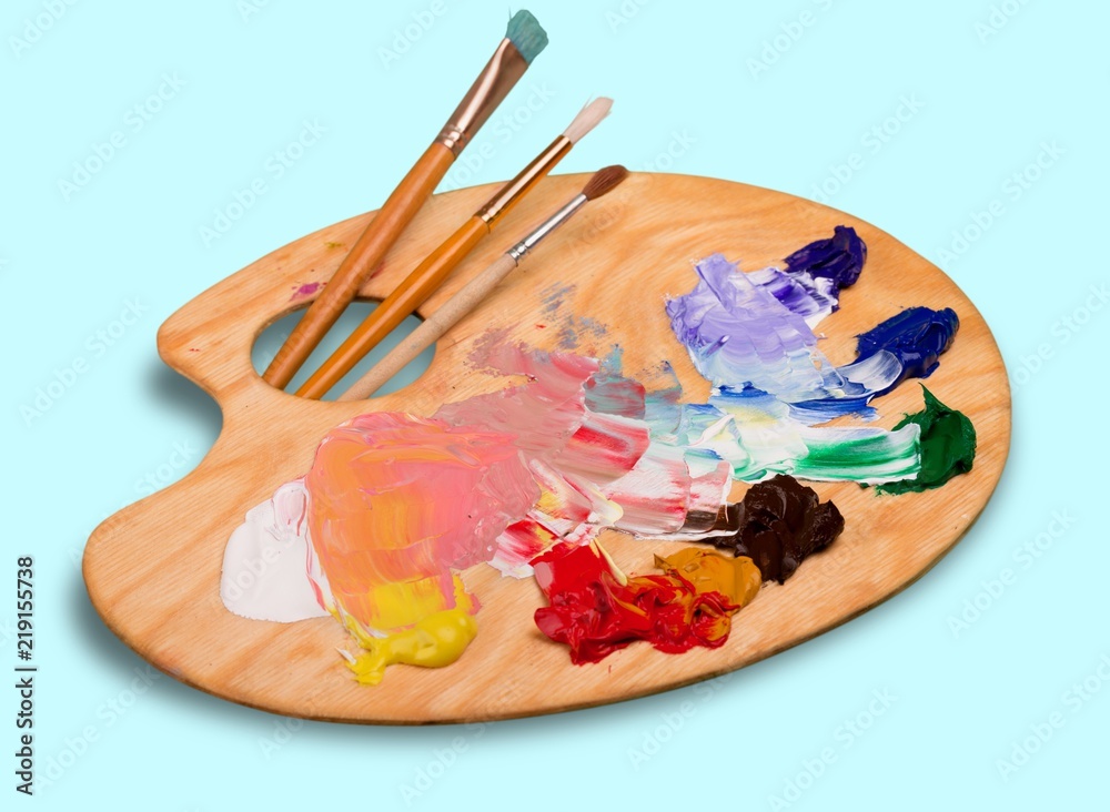 木制艺术调色板，白色上有颜料斑点和画笔