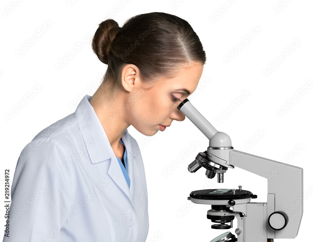 在白色显微镜下工作的年轻女科学家