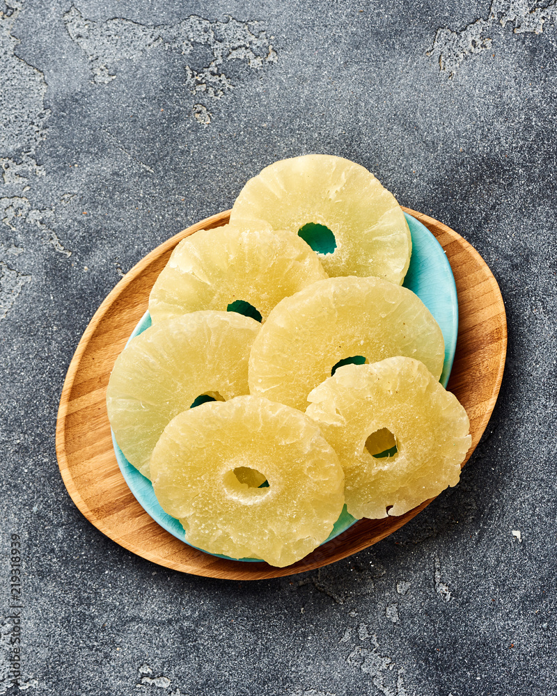 Dried pineapple rings on a gray table. Top viw of sweet paneapple slices.