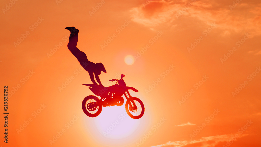 极限职业越野摩托车手在阳光下自由泳跳跃技巧