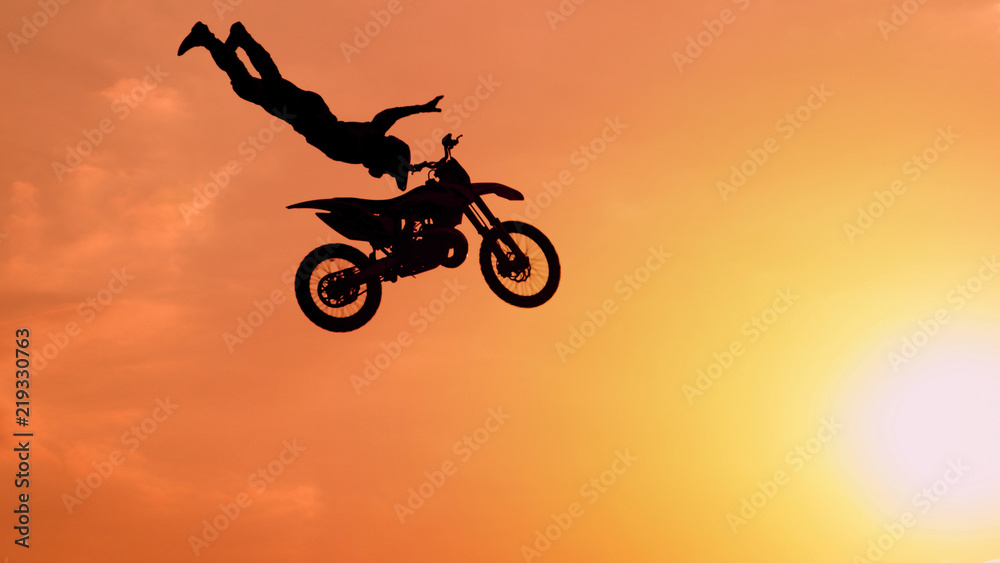 极限职业越野摩托车手在阳光下自由泳跳跃技巧