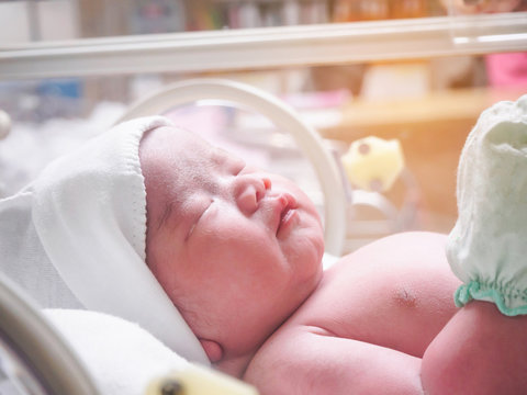 Newborn baby inside incubator in hospital post delivery room