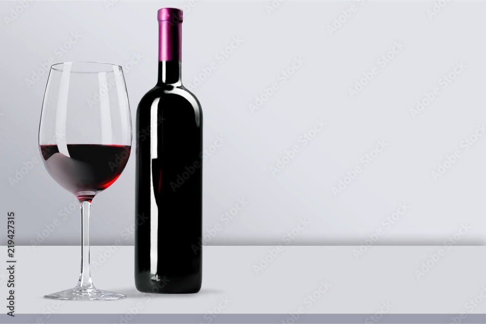 白底瓶装和玻璃杯中的红酒