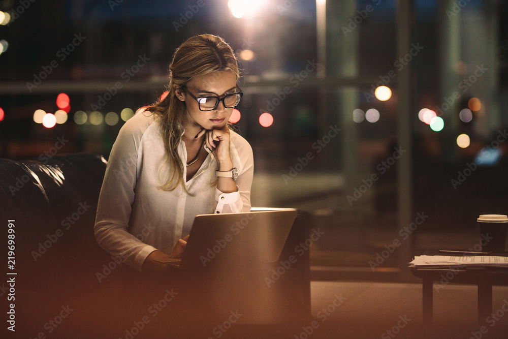 商务女性在笔记本电脑上工作到很晚