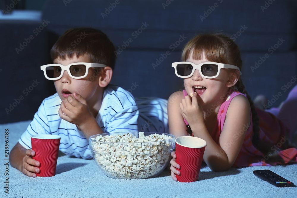 晚上戴着3d眼镜在地毯上看电影的可爱孩子