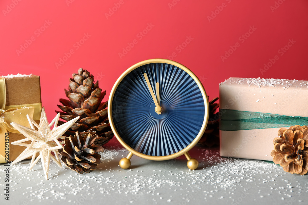 灰色桌子上有礼物和装饰品的闹钟。圣诞节倒计时