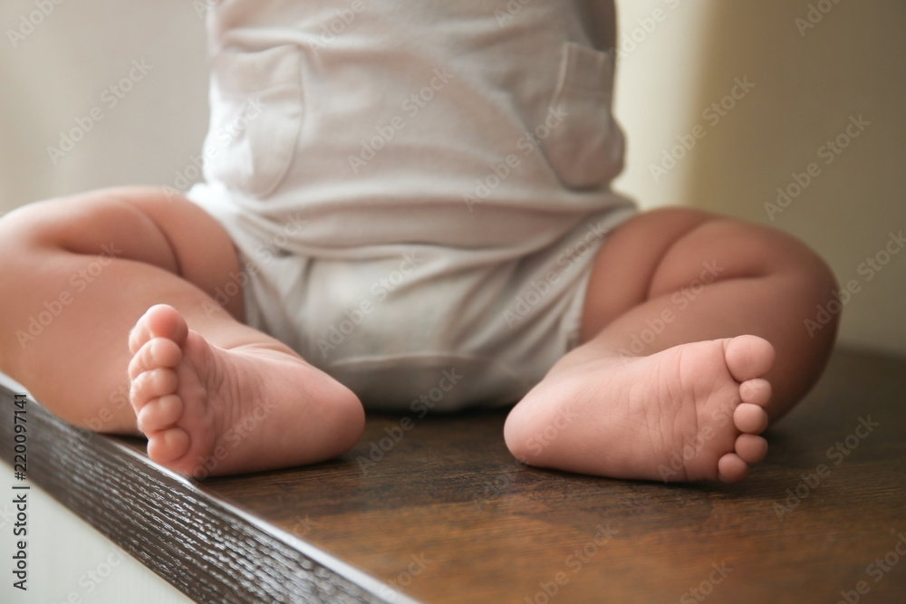 坐在桌子上的可爱婴儿的腿
