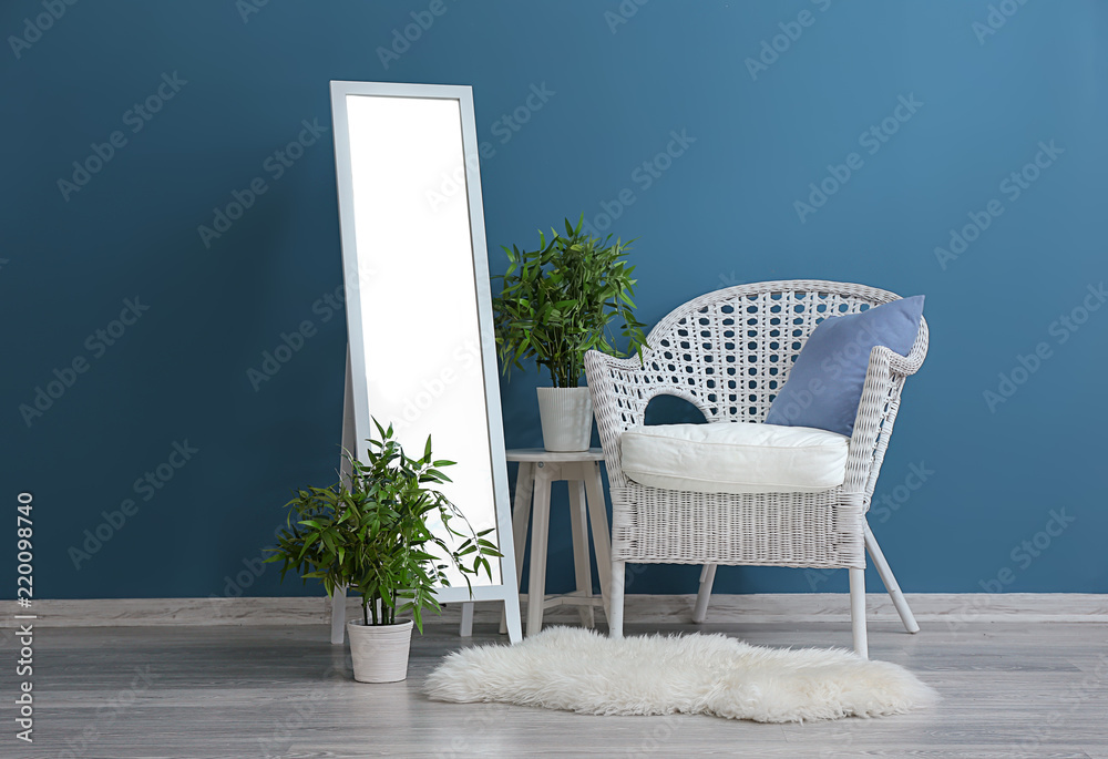 室内彩色墙壁附近有扶手椅和植物的时尚大镜子