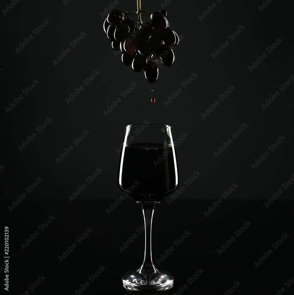 一杯红葡萄酒和黑底葡萄