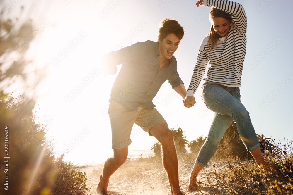 快乐的男人和女人在海滩上跑步玩得很开心