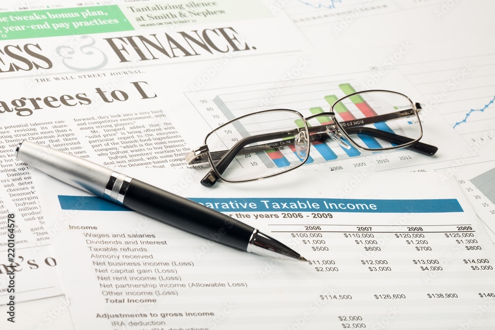 Pen And Glasses On Financial Reports And Newspaper Close-up