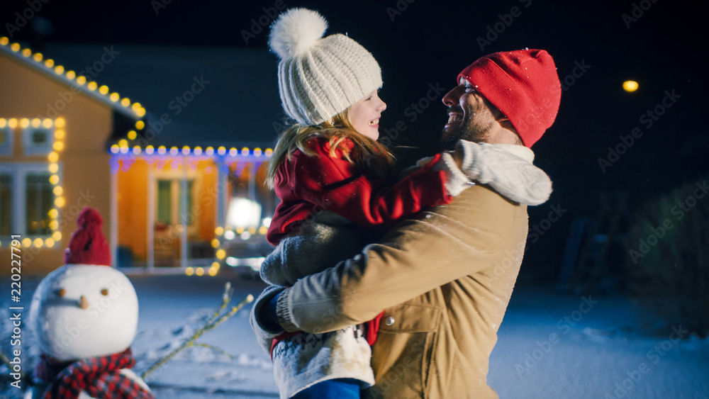 慈爱的年轻父亲拥抱她可爱的小女儿-拥抱。与家人团聚的快乐冬夜