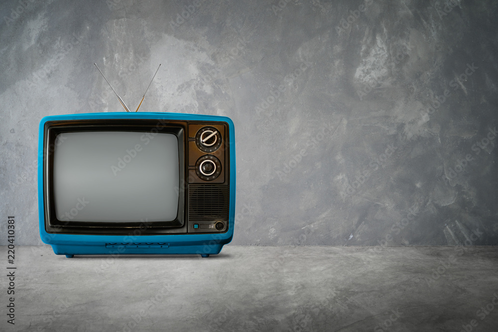 背景水泥桌上的蓝色复古复古电视。