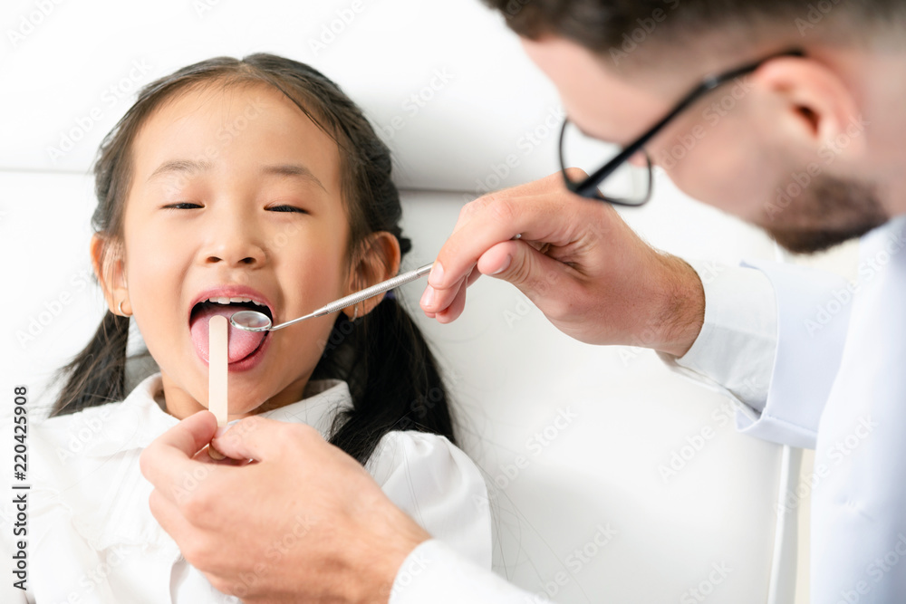 牙医在牙科诊所检查儿童牙齿。