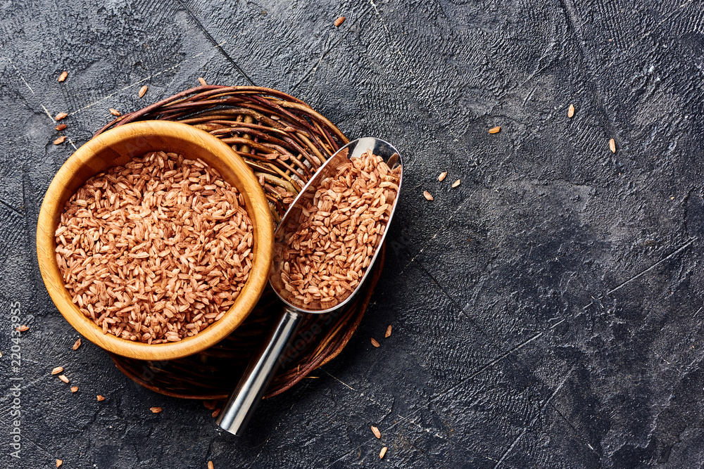 黑色背景木碗中的野生糙米，有复制空间。谷物俯视图。