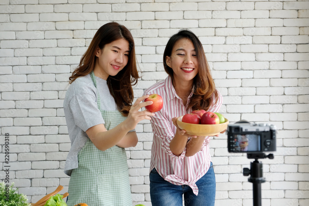 两位年轻的亚洲女性美食博主在录制视频、vlog概念、人物和技术时交谈