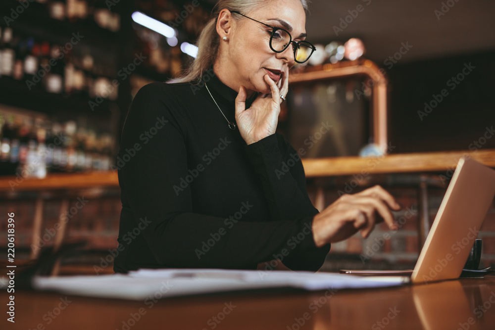 漂亮的资深自由职业女性在咖啡馆使用笔记本电脑