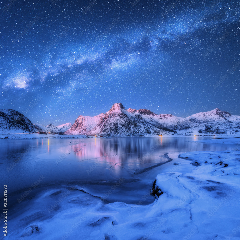 北罗弗敦群岛冬季夜间冰冻海岸和白雪皑皑的山脉上方的银河系