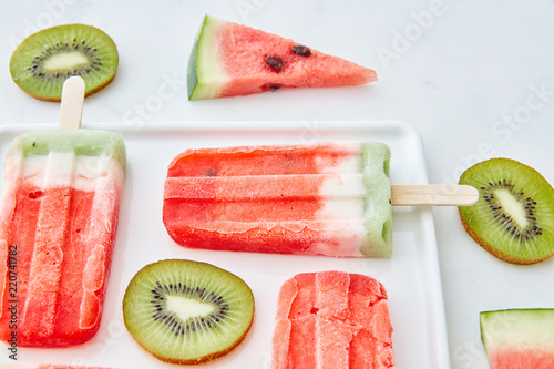 西瓜冰淇淋放在一根棍子上，用猕猴桃片和多汁的西瓜片装在一个篮子里