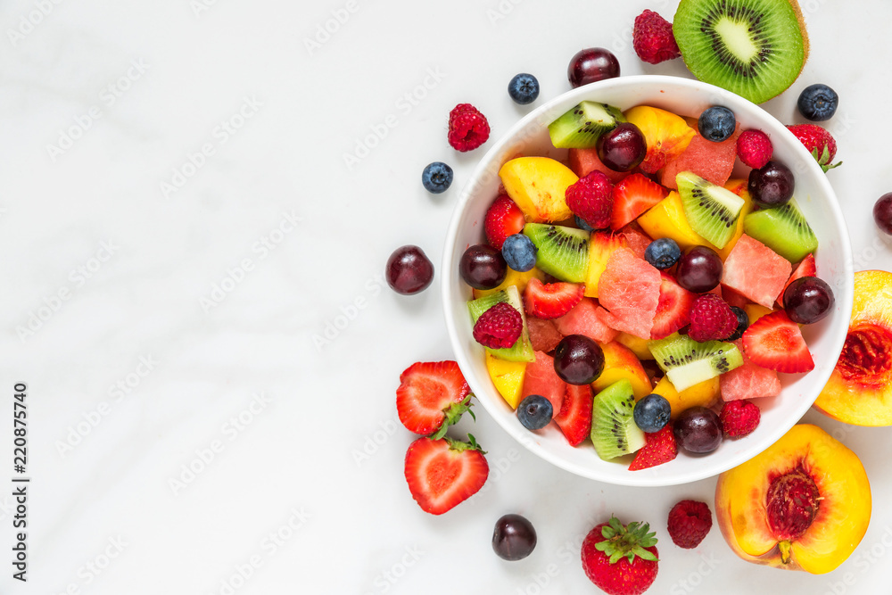 一碗白色大理石背景的健康新鲜水果沙拉。健康食品。俯视图