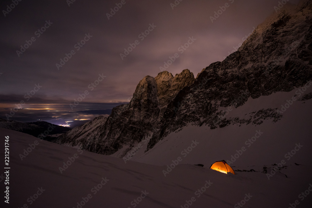 星空和银河下的橙色帐篷。在星空下的极限和冒险冬季露营