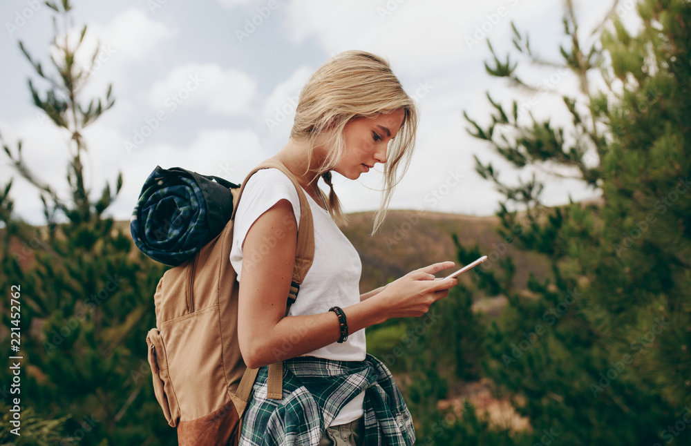 一名女性旅行者看手机的侧视图