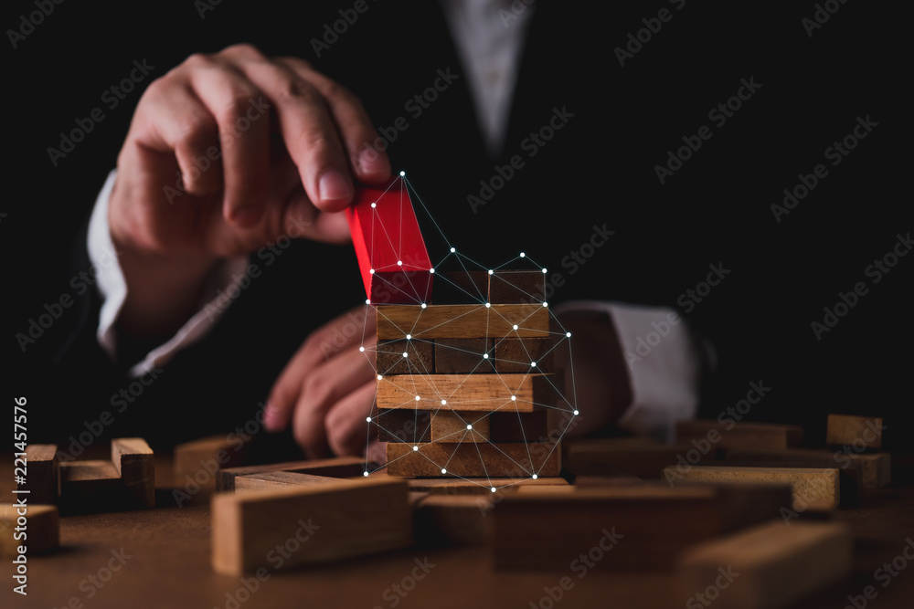 商人试图在木桌和黑色背景上建造木块商业组织之星
