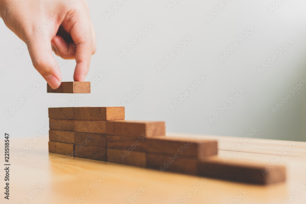 手工安排木块堆放作为阶梯。阶梯式职业道路概念，促进业务成功增长