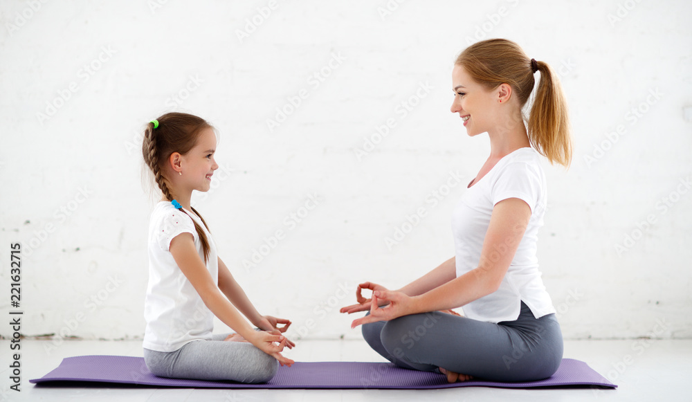 mother with child practicing yoga in lotus pose .