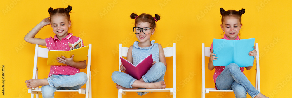 funny children girls read books on a colored yellow background