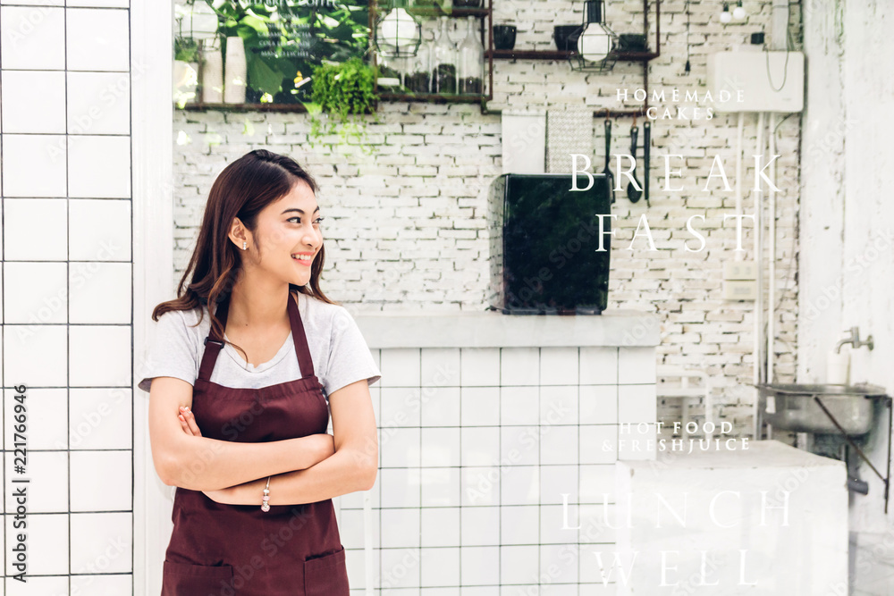女小企业主微笑着双臂交叉站在咖啡馆或咖啡厅外的肖像