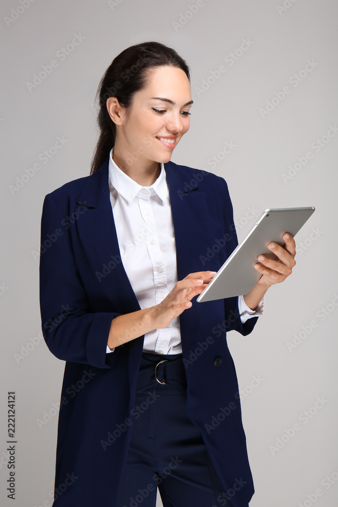 美丽的女商人，灰色背景下的平板电脑