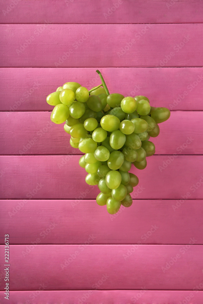彩色木质背景上的新鲜成熟葡萄