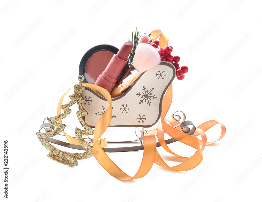 Small Christmas sleigh with decorative cosmetics on white background