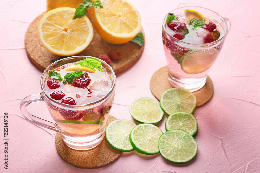 彩色桌子上的新鲜树莓柠檬水玻璃杯