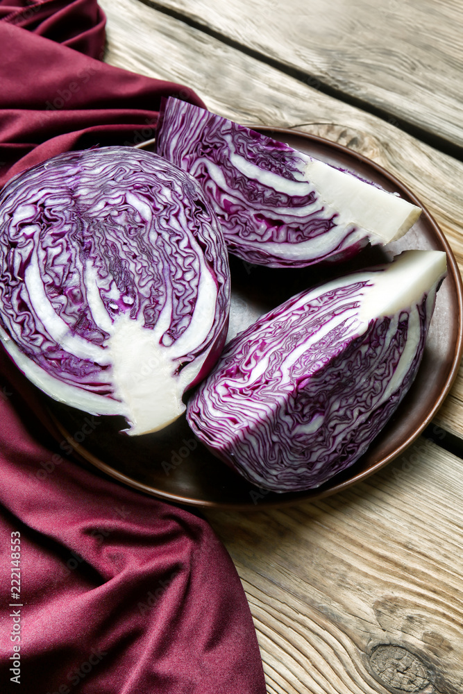 Plate with ripe red cabbage on wooden table