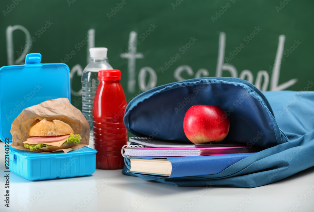 教室桌子上放着笔记本和开胃食品的袋子