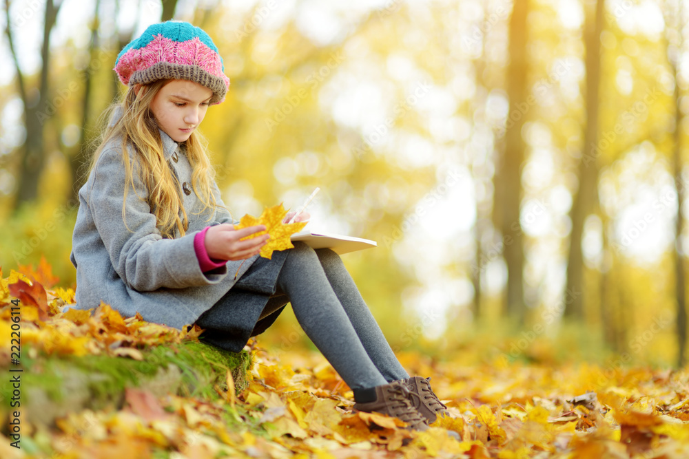 美丽的秋日，可爱的小女孩在室外写生。快乐的孩子在秋天的公园玩耍。孩子